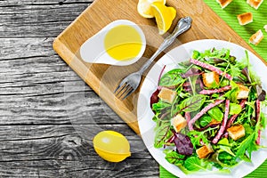 Delicious fresh salad of salami and mixed lettuce leaves - baby