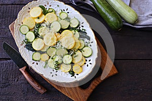 Delicious fresh salad with zucchini, kale and parmesan cheese with spices and olive oil. Selective focus, top view