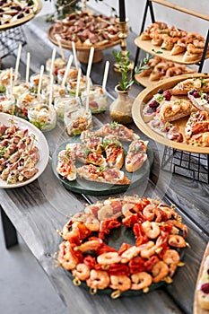 Delicious fresh seafood, shrimp with fresh vegetables. buffet table with lots of delicious snacks. canapes, bruschetta