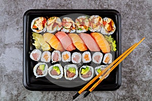 Delicious fresh sushi roll set on a black tray. Japanese food