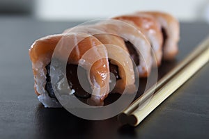 Delicious fresh sushi rolls with salmon and cream cheese on black plate. Traditional japanese food, healthy food concept