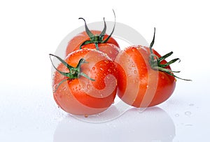 Delicious fresh tomatoes, close up shot, isolated on white background. Gourmet food or healthy eating