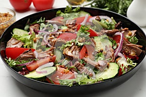 Delicious fresh tuna salad on white table, closeup