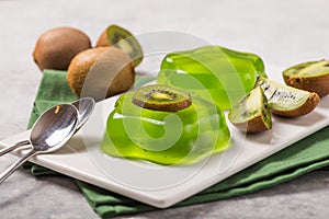 Delicious fresh two green jelly with kiwi slices on concrete table