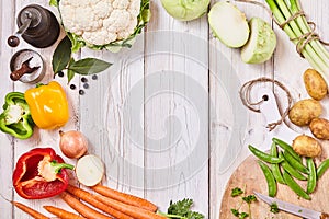 Delicious fresh veggies forming a frame on wood photo