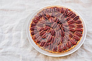 Delicious freshly baked homemade pecan pie on white background