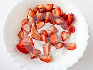 Delicious freshly cut strawberries with greek yoghurt  on a white plate. Healthy snack idea. Healthy food. Isolated on white