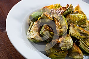 Delicious fried artichoke halves on a white plate