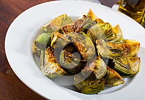 Delicious fried artichoke halves on a white plate