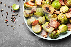 Delicious fried Brussels sprouts with bacon on table, flat lay