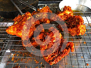 Delicious fried chicken placed on the grill