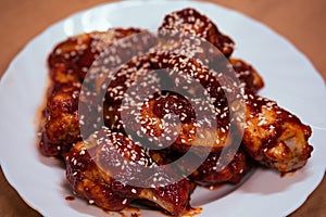 Delicious fried chicken wings in buffalo sauce with sesame seeds. Fast junk food