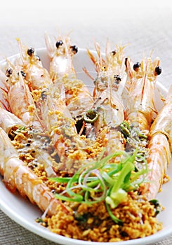 Fried shrimps on a plate topping with minced garlic