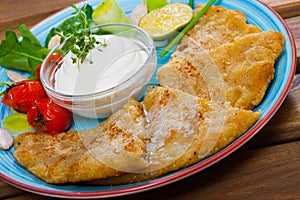 Delicious fried Tattie scones from mashed potatoes served with sour cream, vegetables and greens. Scottish cuisine
