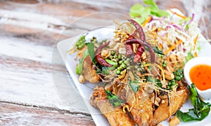 Delicious, fried wing chicken with herb, pepper, chilli, salad, and sauce, famous thai or asian food