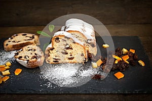 Delicious fruit cake sprinkled with vanilla sugar, slice of fruit cake on rustic stone plate