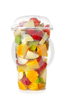 Delicious fruit salad in plastic cup on white background