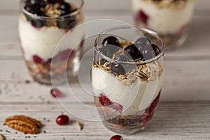 Delicious fruit yogurt parfait cups filled with layers of muesli, chia seeds, fresh berries, rolled oats, and homemade yogurt