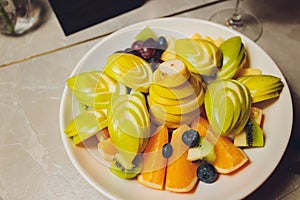 Delicious fruits salad in plate on table close-up.