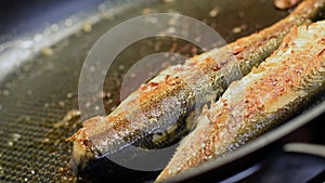 Delicious fryed fishes on hot frying pan.