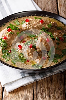 Delicious Georgian satsivi with chicken and pomegranate close-up in a bowl. vertical