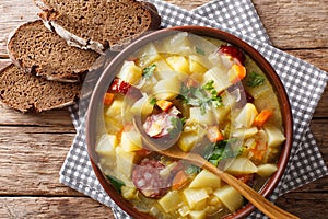 Delicious German potato vegetable soup with sausages in a bowl c