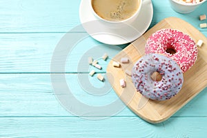 Delicious glazed donuts on blue wooden table, above view. Space for text