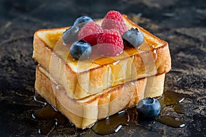 Delicious Golden French Toast Topped with Fresh Berries and Drizzled Honey photo