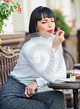 Delicious gourmet cake. Woman attractive brunette eat gourmet cake cafe terrace background. Gastronomical enjoyment