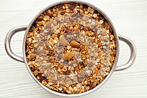 Delicious granola muesli with nuts and raising in big bowl, flat