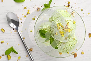 Delicious green ice  served in dessert bowl on white wooden table, top view