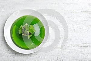 Delicious green jelly with kiwi slices on  wooden table, top view. Space for text