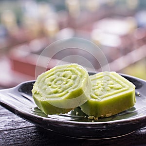 Delicious green mung bean cake with black tea plate on wooden railing of a teahouse in Taiwan with beautiful landscape in