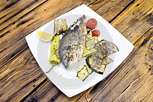 Delicious Grilled bream or dorade fish on wooden background