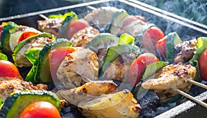 delicious grilled chicken meat shish kebob or kabob with vegetables on barbecue grill with smoke and flames. popular outdoor