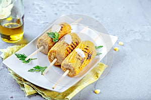 Delicious grilled corn on wooden background closeup.
