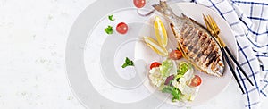 Delicious grilled dorado or sea bream fish with salad, spices, grilled dorada