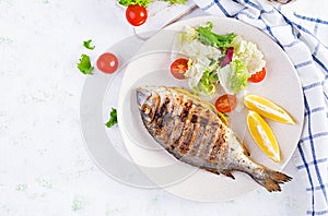 Delicious grilled dorado or sea bream fish with salad, spices, grilled dorada