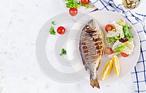 Delicious grilled dorado or sea bream fish with salad, spices, grilled dorada