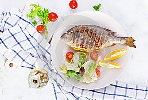 Delicious grilled dorado or sea bream fish with salad, spices, grilled dorada