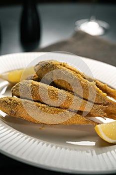 Delicious grilled red mullet fish with lemon serving on table in restaurant. Top view photo