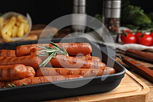 Delicious grilled sausages with rosemary on table, closeup