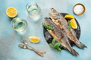 delicious grilled seabass fish with lemon and spices with white wine. banner, menu, recipe place for text, top view