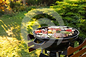 Delicious grilled vegetables and meat on barbecue grill outdoors
