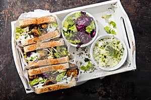 Delicious gyros sandwich in paper bag with salad and tzatziki