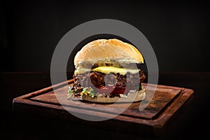 Delicious hamburger isolated in a wooden table with a black background