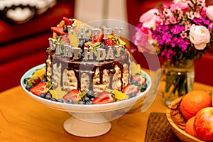 Delicious handmade layered cake decorated with Happy birthdays candles photo