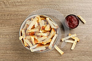 Delicious hard chucks with ketchup on wooden table, flat lay