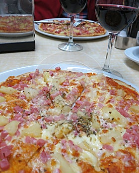 Delicious Hawaian pizza and a glass of red wine