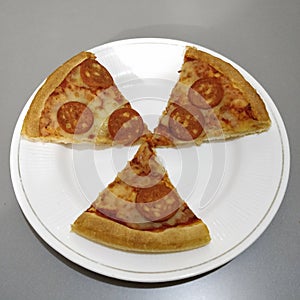 Delicious and healthful pepperoni pizza triangular shaped sliced in a plate